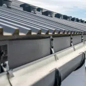 Gutter system for a metal roof. Holder gutter drainage system on the roof.