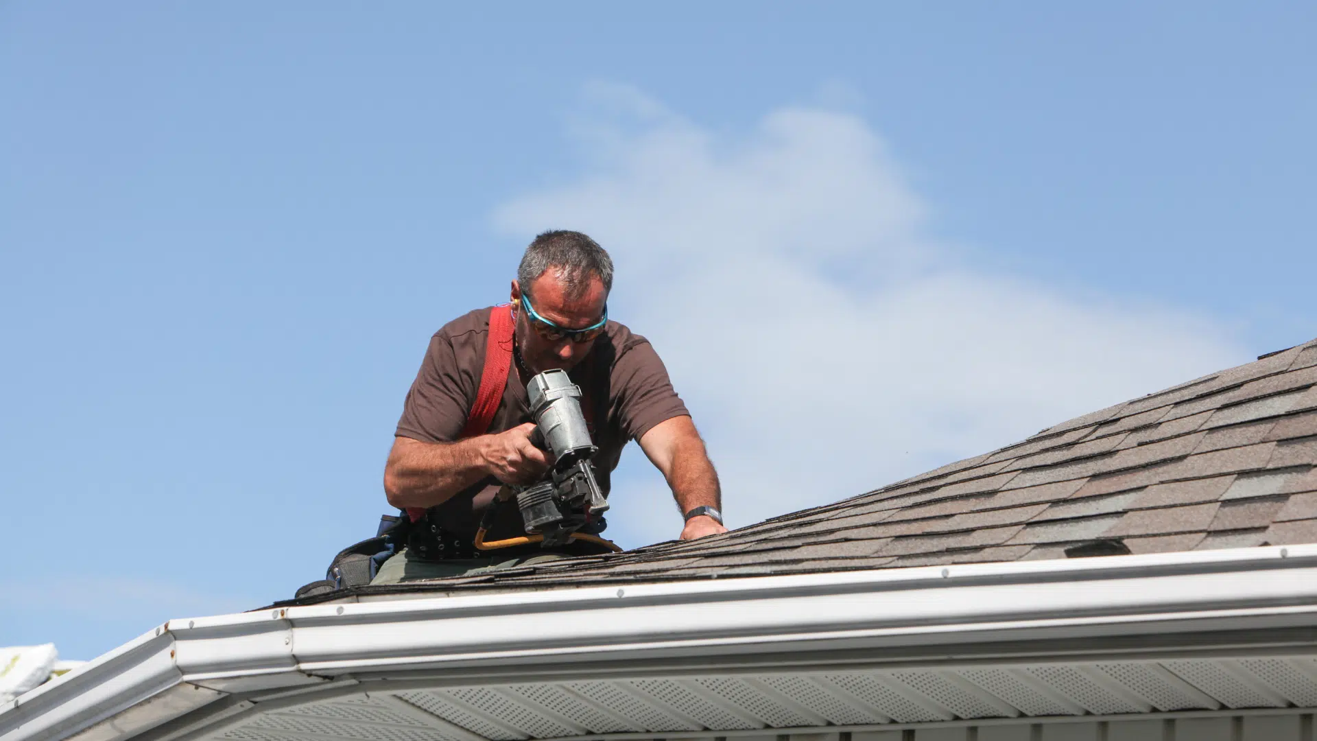 man above the roof wearing sunglasses